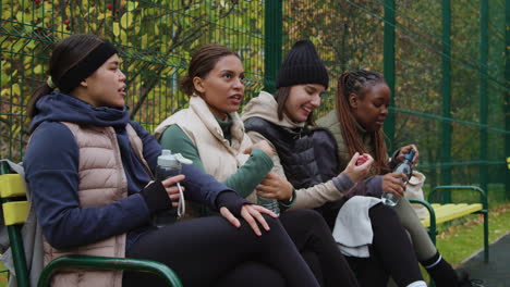 women sitting on a bench after sports