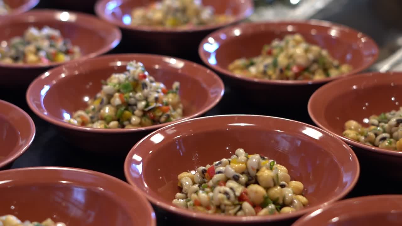 Bowls of colorful bean salad made with chickpeas, black-eyed peas, and chopped vegetables, close up shot ,high angle shot