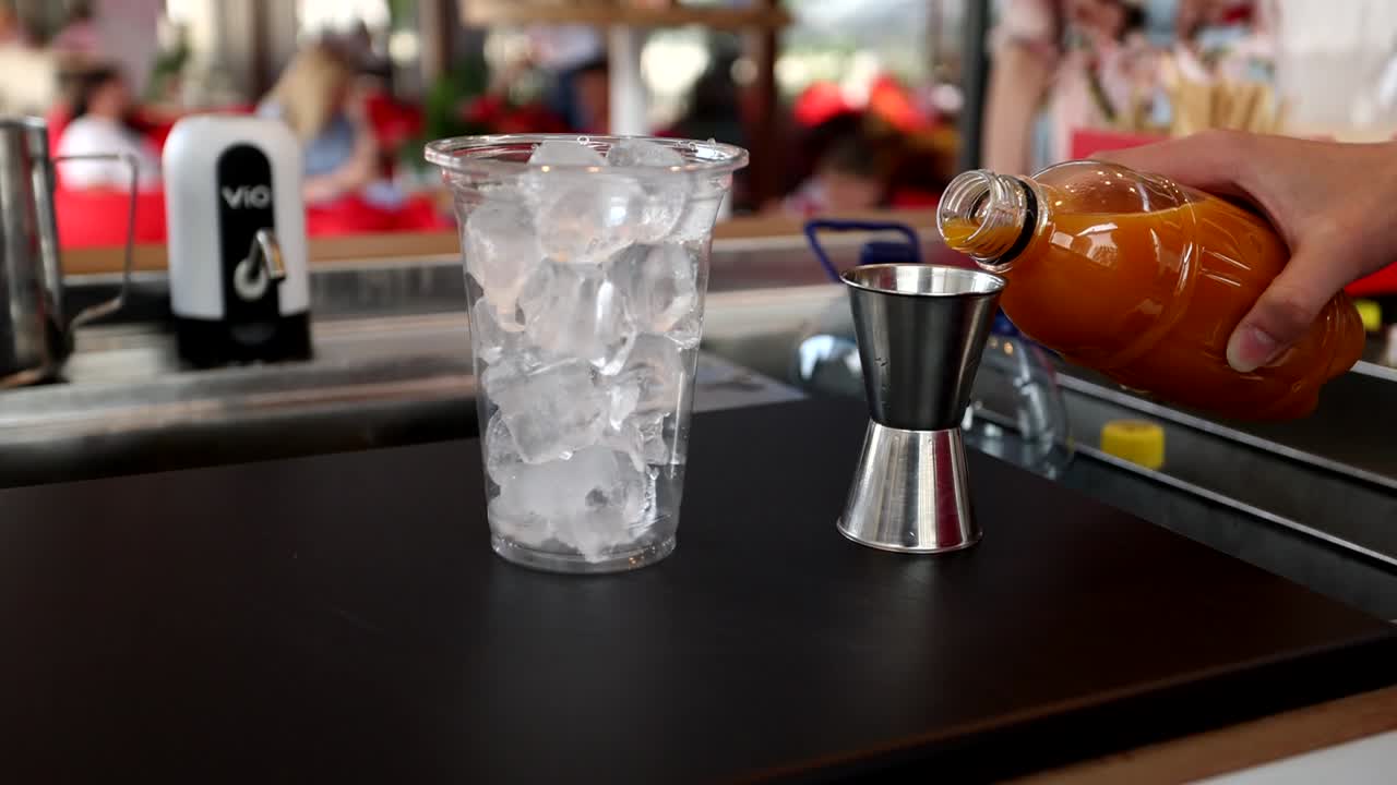 vertiendo jugo de naranja en una taza de medida
