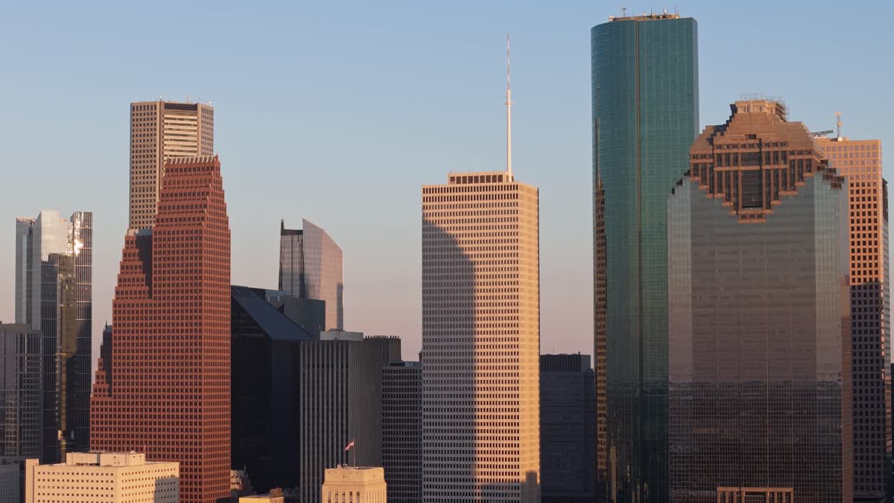 Houston Texas skyscrapers illuminated in warm morning light, drone establishing shot