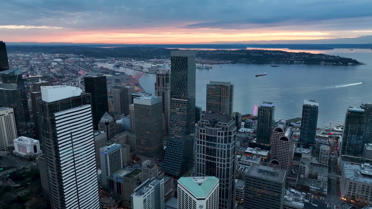 Aerial view of the sun setting behind Seattle's gloomy downtown skyscrapers