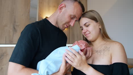 lovely caucasian couple holding a newborn. happy parents of a tiny boy. close up portrait.