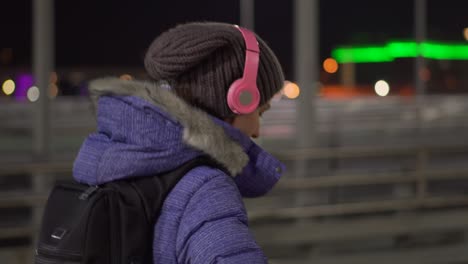 attractive woman using mobile phone during walk on streets of night town