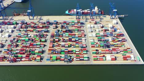 container ship in import export and business logistic, by crane, trade port, shipping cargo to harbor, international transportation, business logistics concept, aerial view