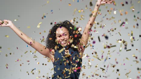 joyful excited woman at celebration party throwing confetti