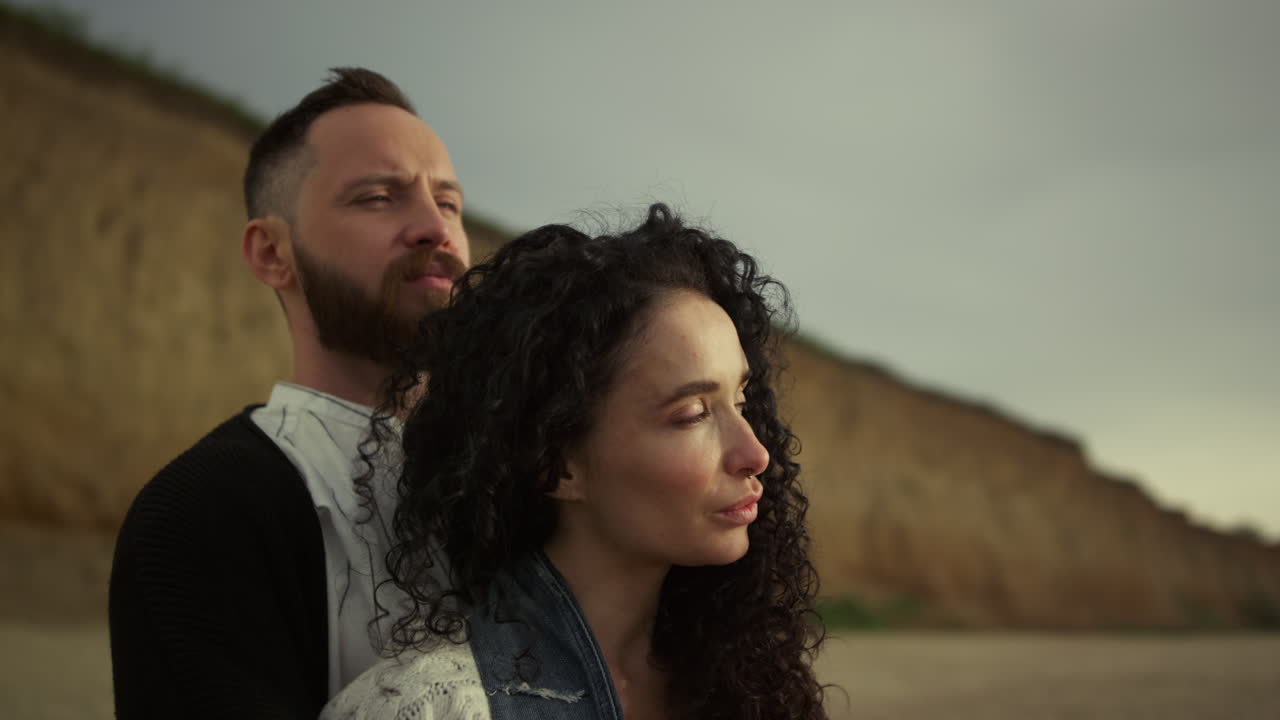 pareja disfrutando de la playa al atardecer, pareja romántica abrazándose en la costa.