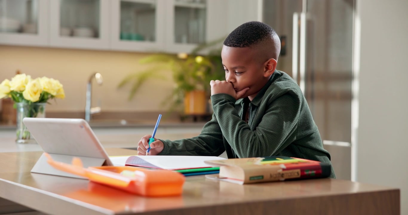 Young Boy Studying with Tablet and Notebook at Home