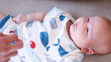 Slow-Motion-Close-Up-Shot-Of-Baby-Boy-Lying-On-Sofa-At-Home-As-Mother-Tickles-Him