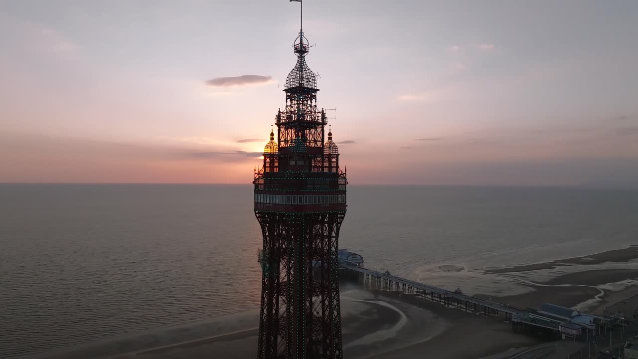 Blackpool Tower observation deck level slow orbit revealing setting sun and North Pier below.