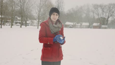 woman holding and playing snowball in a cold winter day - handheld, medium shot