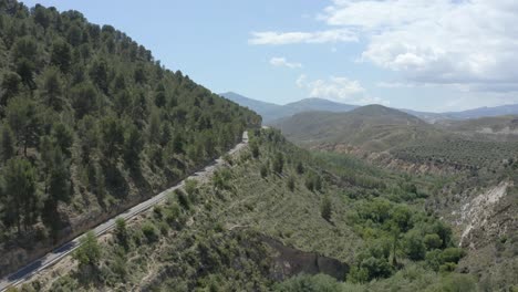 Striking-green-mountainous-terrain-with-a-road-running-through-and-blue-sky