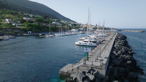 4k aerial of salina marina. low and slow as boats pack up from a day sailing, italy