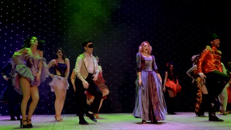 un grupo de héroes de cuentos de hadas están bailando y cantando en el escenario del teatro