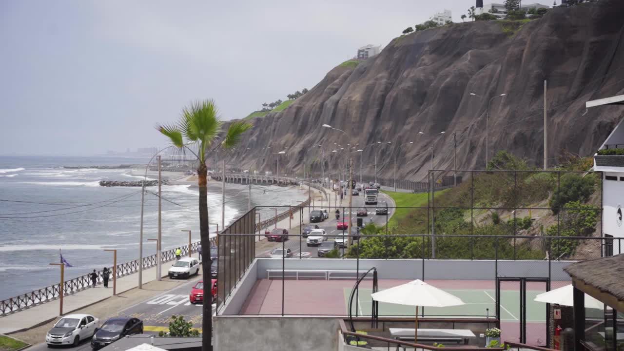 toma en cámara lenta del horizonte de autos en la carretera al lado de la playa en lima perú