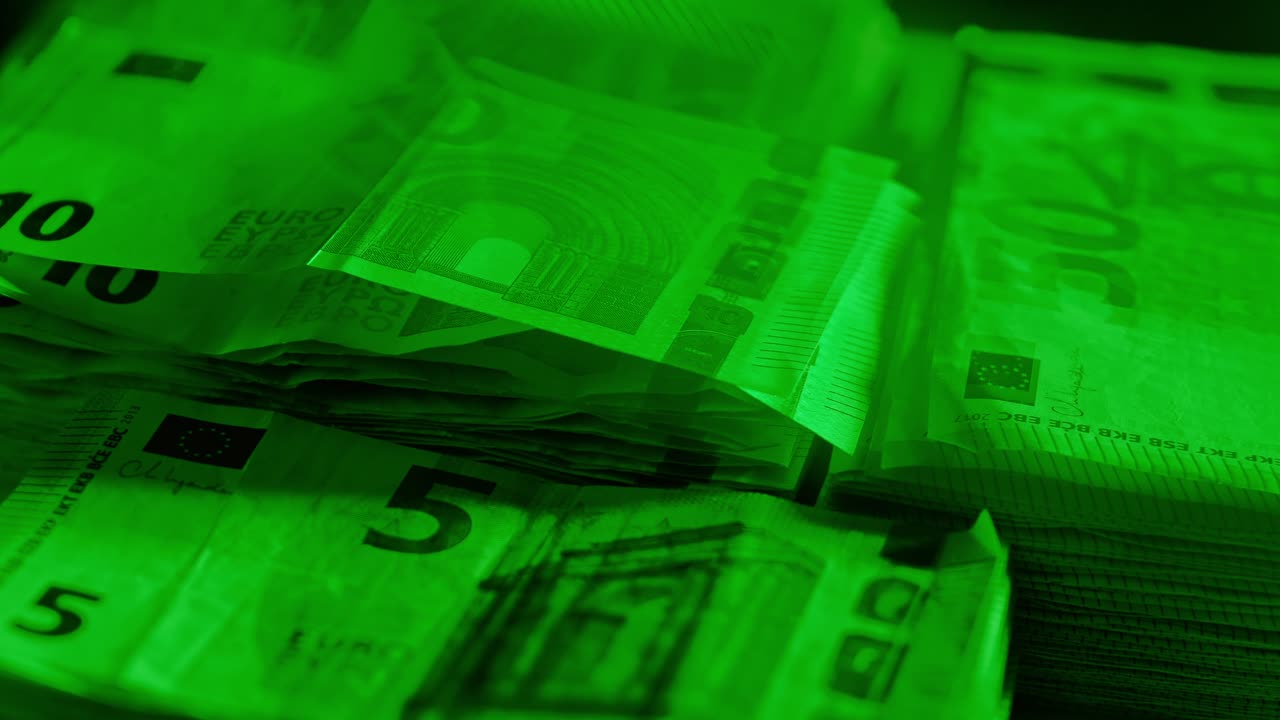 Green-lit euro banknote stack spinning slowly symbolizing economic control