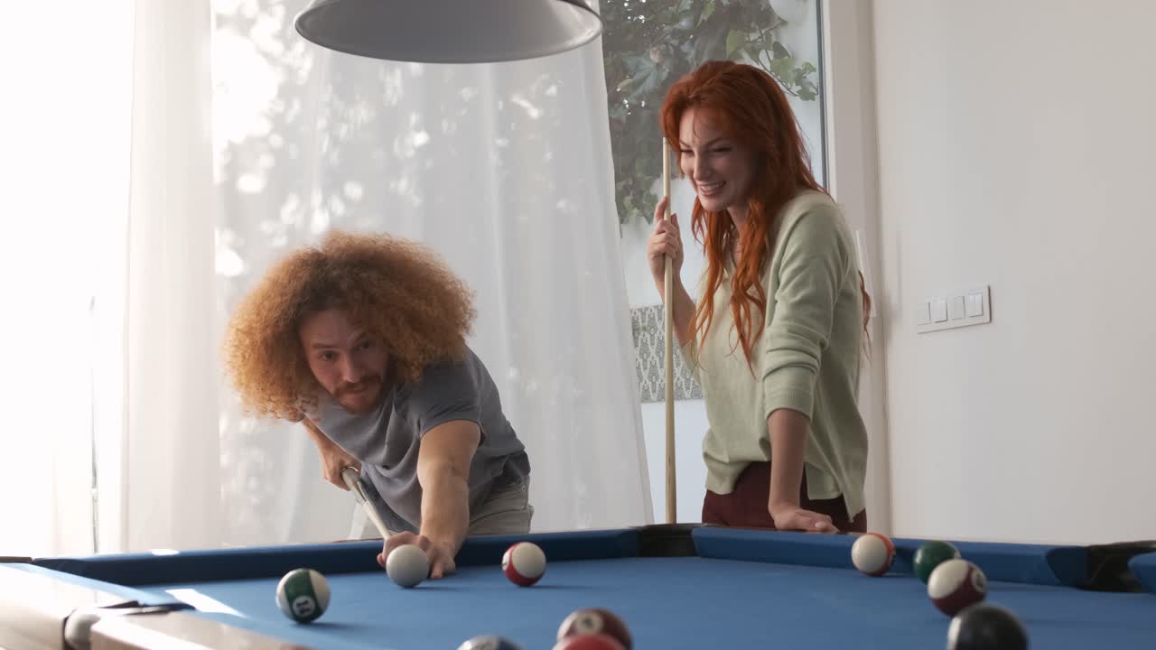 Friends playing pool in game room at home on weekend