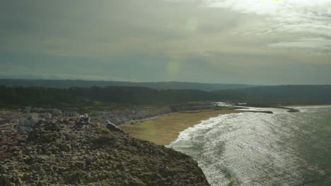 Ein-Paar-Möwen-Sitzen-Am-Rand-Einer-Klippe-Vor-Der-Küste-Von-Nazaré,-Portugal