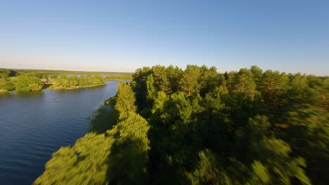Drone-flying-over-treetops-of-an-island-in-lake-Baluosas,-Lithuania