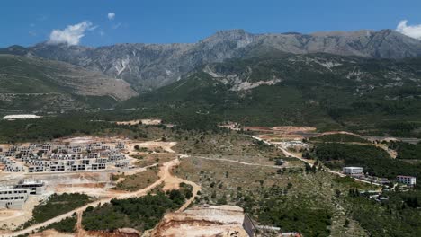 gran complejo en construcción en la ladera con montañas en el fondo