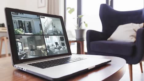 laptop on coffee table in living room with home security camera views on screens, slow motion