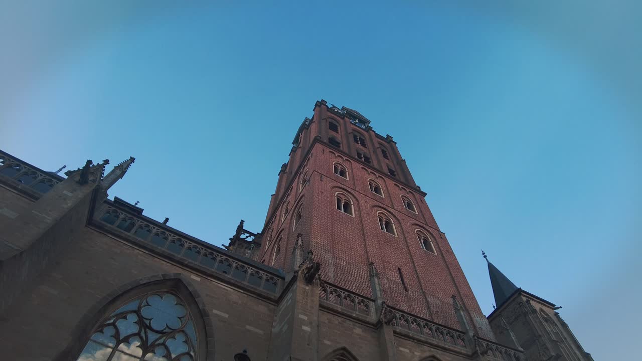 Looking up at gigantic brick stone church tower in the Netherlands s Hertogenbosch