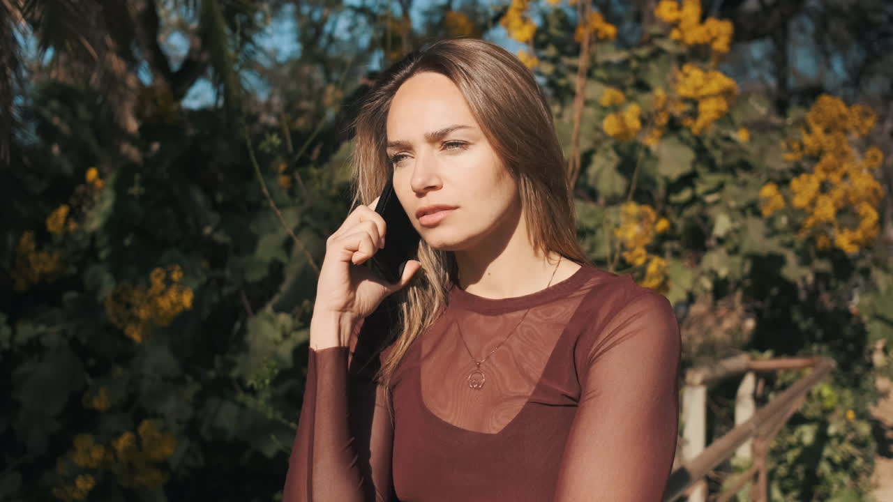 젊은 여성이 야외에서 스마트폰을 사용하고 있습니다.