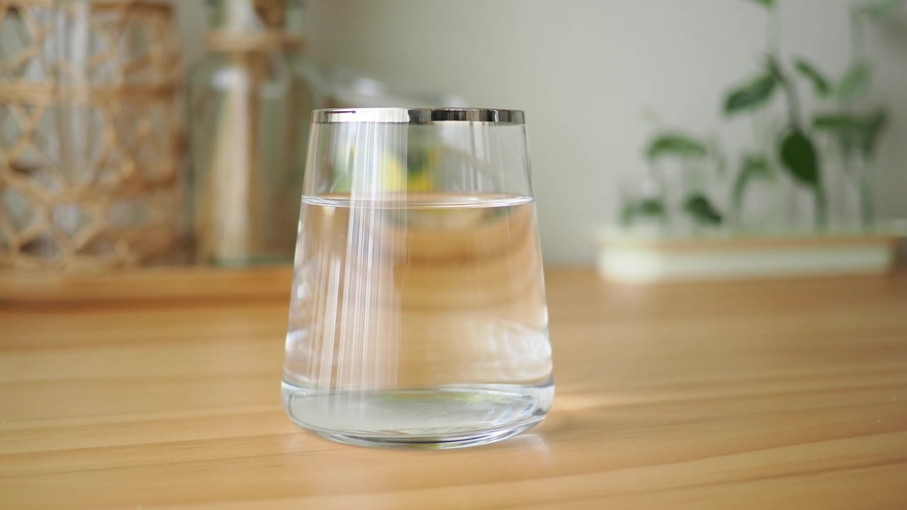 Un bicchiere d'acqua trasparente su un tavolo di legno
