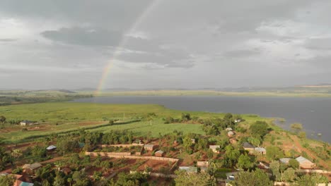 aerial shot of rural villages with a rainbow in the background in africa