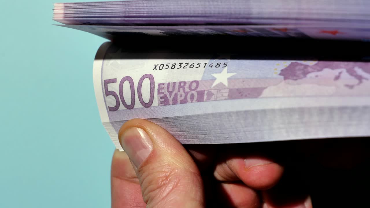 Disse hænder holder mange penge, og med tommelfingrene kan indehaveren bladre gennem disse eurosedler