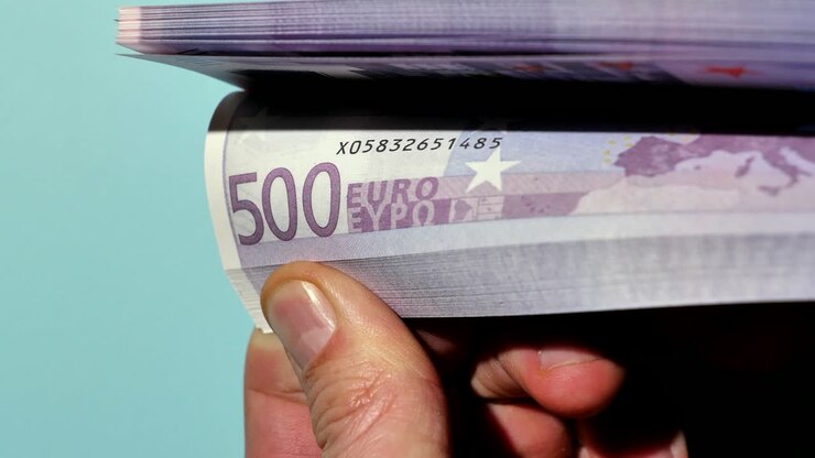 Disse hænder holder mange penge, og med tommelfingrene kan indehaveren bladre gennem disse eurosedler