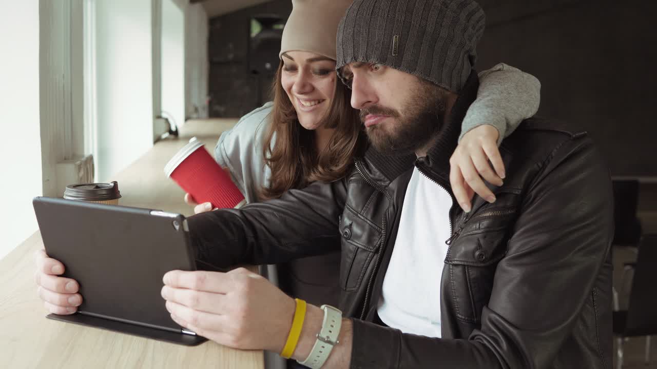 reunión de trabajo en la oficina creativa. hombre joven y mujer usando una tableta para tomar fotos y divertirse. llamada de conferencia. filmado en 4k