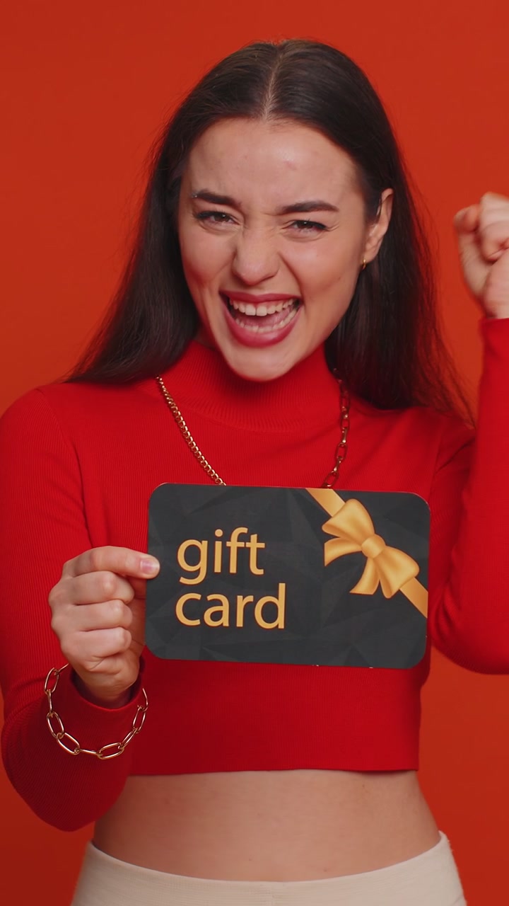 Giovane donna che mostra indicando un buono sconto su un certificato di sconto in regalo per la vendita di vacanze in negozio