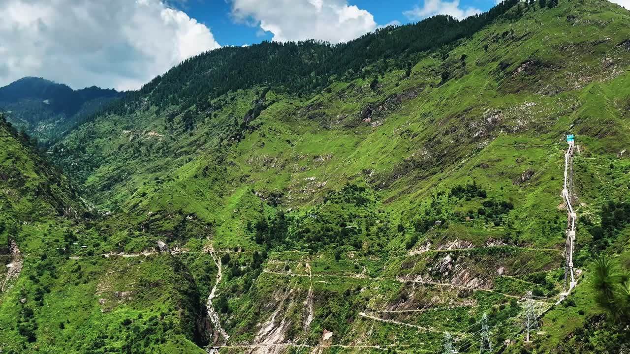 Lush green hills of Nichar with winding roads and forested slopes, panning shot
