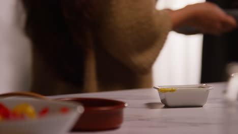 부에서 건강한 채식주의자 또는 채식주의자의 식사를 준비하는 집에 있는 여성의 근접 사진, 씨과 드레싱이 있는 러드 잎의 그을 먹는 모습