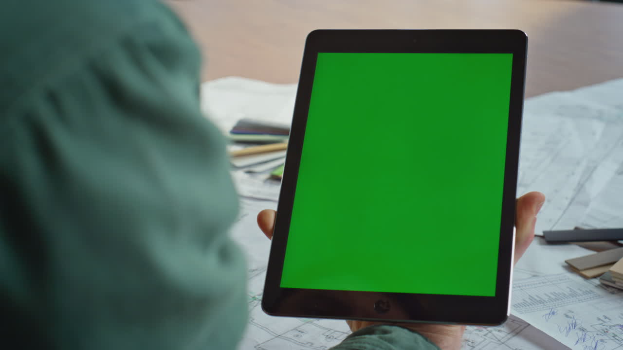 Project manager touching greenscreen tablet working plans in office closeup