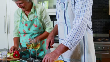 Senior-couple-cutting-vegetables-in-kitchen-4k