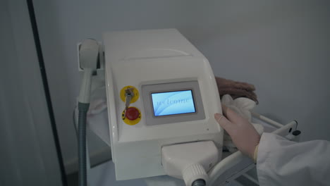 hand adjusting laser machine in beauty center closeup. cosmetician preparing