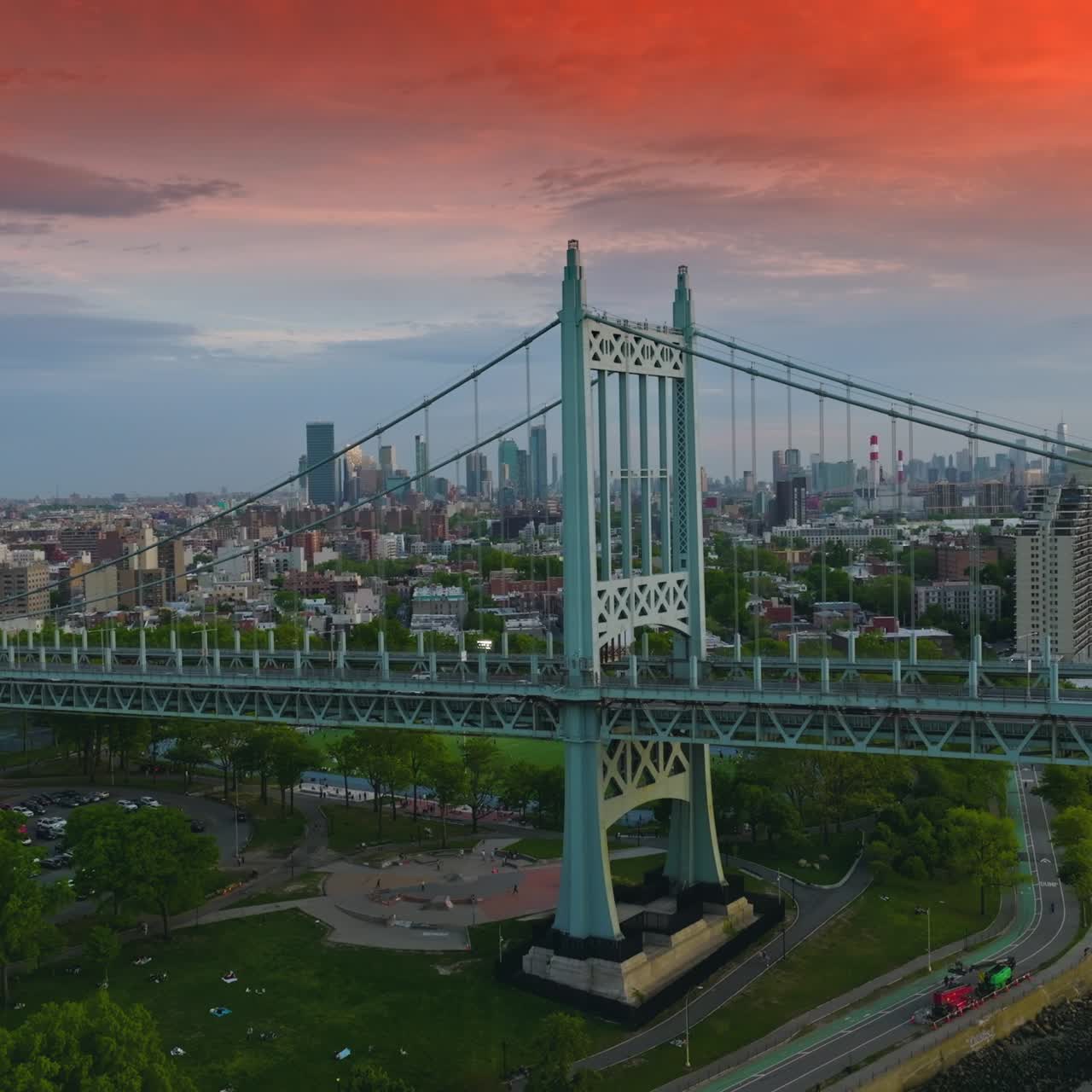 Pink sky with clouds over New York city. The Triborough bridge at the backdrop of busy cityscape