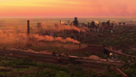 chimeneas industriales con emisiones de humo, contra los vívidos tonos de la luz solar naranja, alto contraste