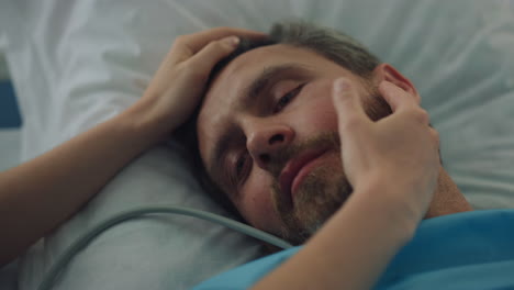 tired patient lying bed after surgical treatment closeup. woman hands touch face