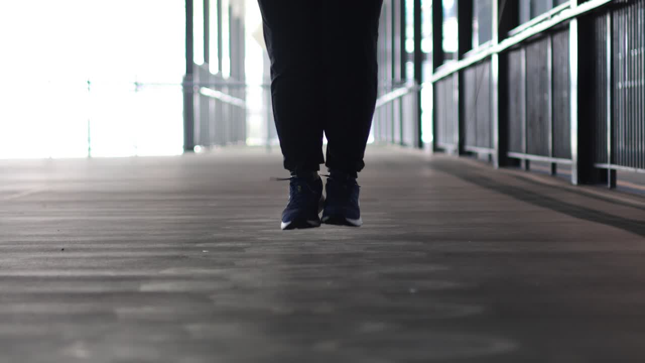 한 사람 이 복도 에서 로프 점프 운동 을 하고 있다