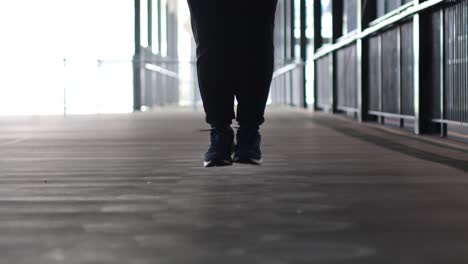 person performs jump rope exercise in a corridor