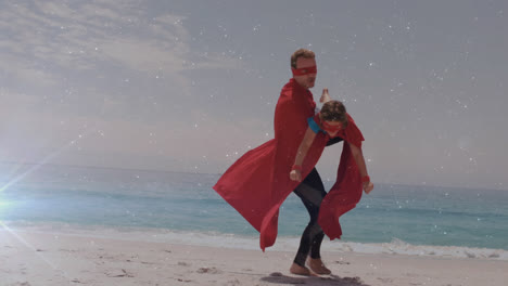 glowing spot of light against father and son in superhero costume on a beach