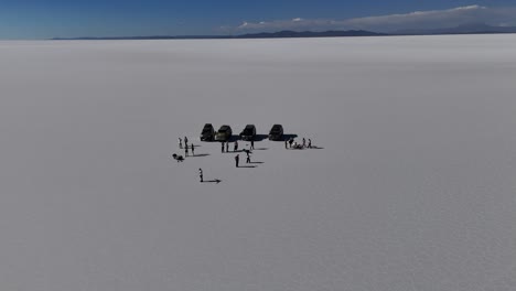 Coches-Y-Personas-En-El-Salar-De-Uyuni,-Bolivia,-Sudamérica,-Desierto,-Salinas,-Paisajes,-Vista-Aérea-De-Drones,-Montañas.