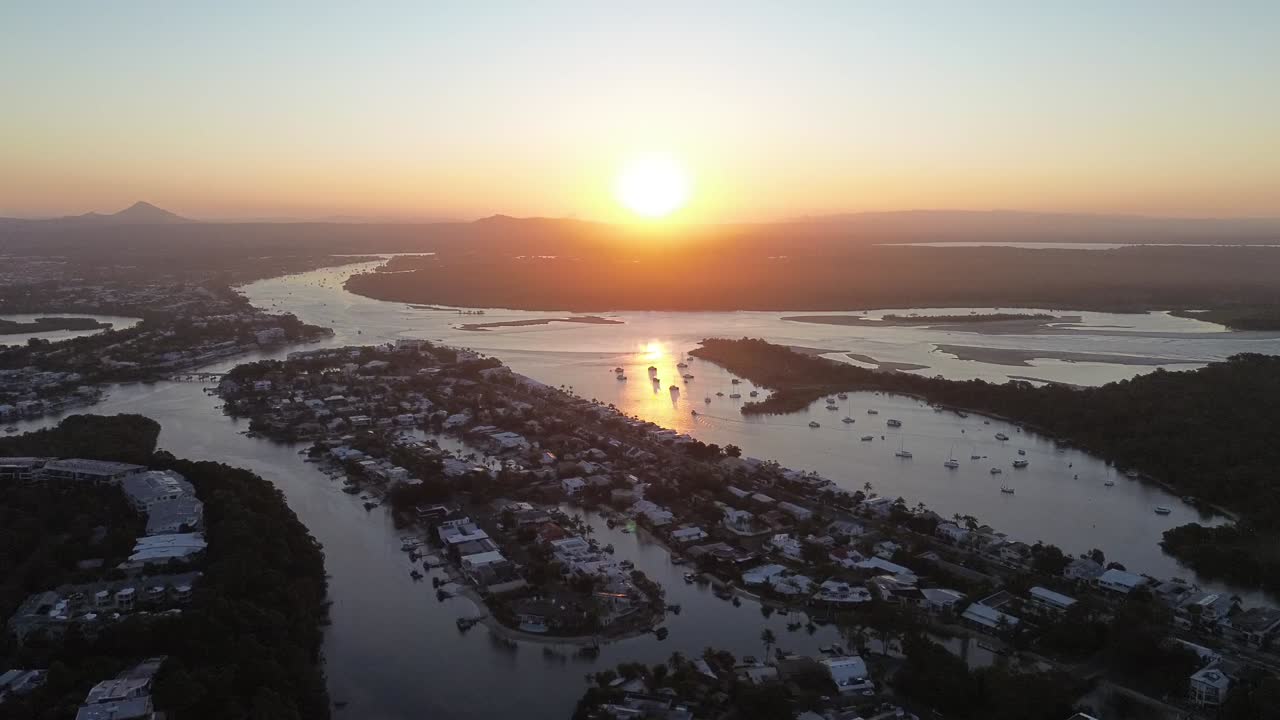 Stunning aerial footage at sunset capturing the beauty of Noosa and the surrounding ocean. The golden light reflects off the water, blending the coastline with the charm of this Australian gem.