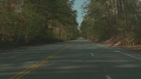 Fahren-Sie-Zur-Herbstzeit-Eine-Von-Bäumen-Gesäumte-Autobahn-Hinunter,-Mit-Herbstlaub-überall