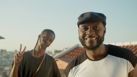 homosexual couple standing on rooftop and posing for camera