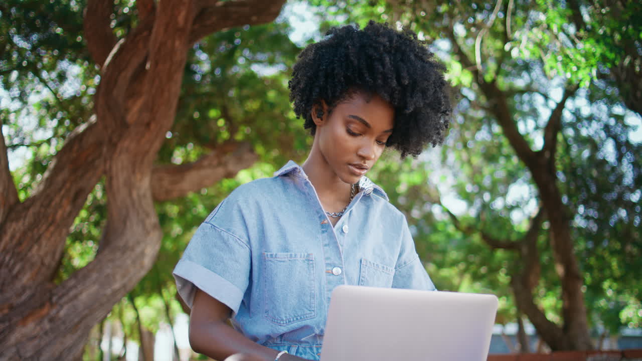Serious freelancer working nature typing on laptop closeup.  girl in park