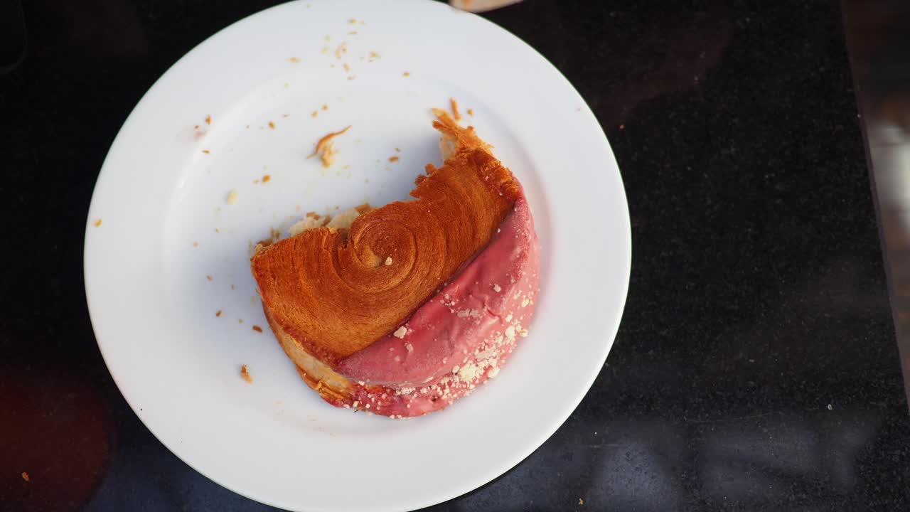 Croissant being cut on a plate