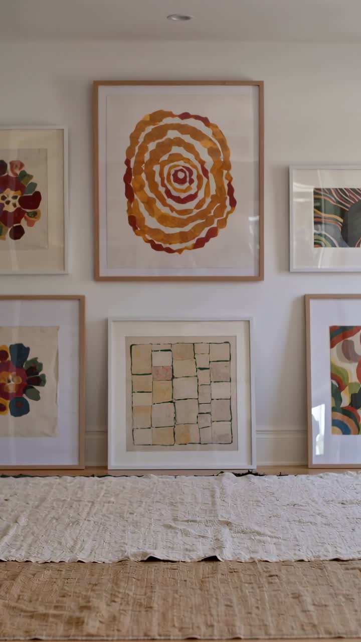 Vídeo vertical: Cámara que se mueve para centrar una obra de arte circular en casa, revelando azulejos cuadrados y alfombras.